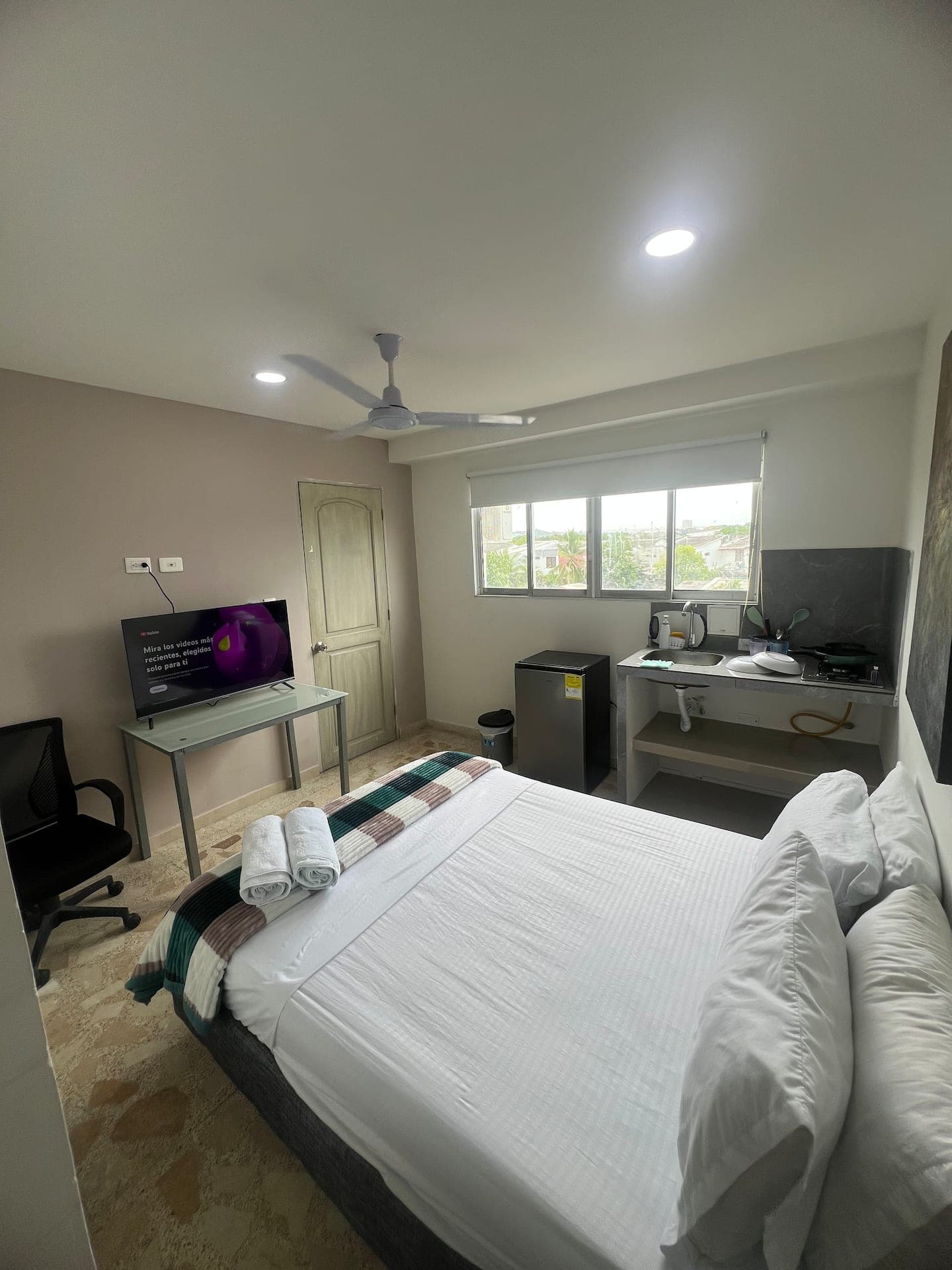Habitación con ventana hacia el barrio de Manga